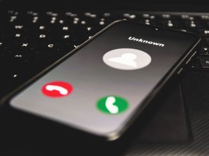 Avoid Cyber Scams During (and After) the Pandemic Photo of cell phone featuring a call from an unknown caller