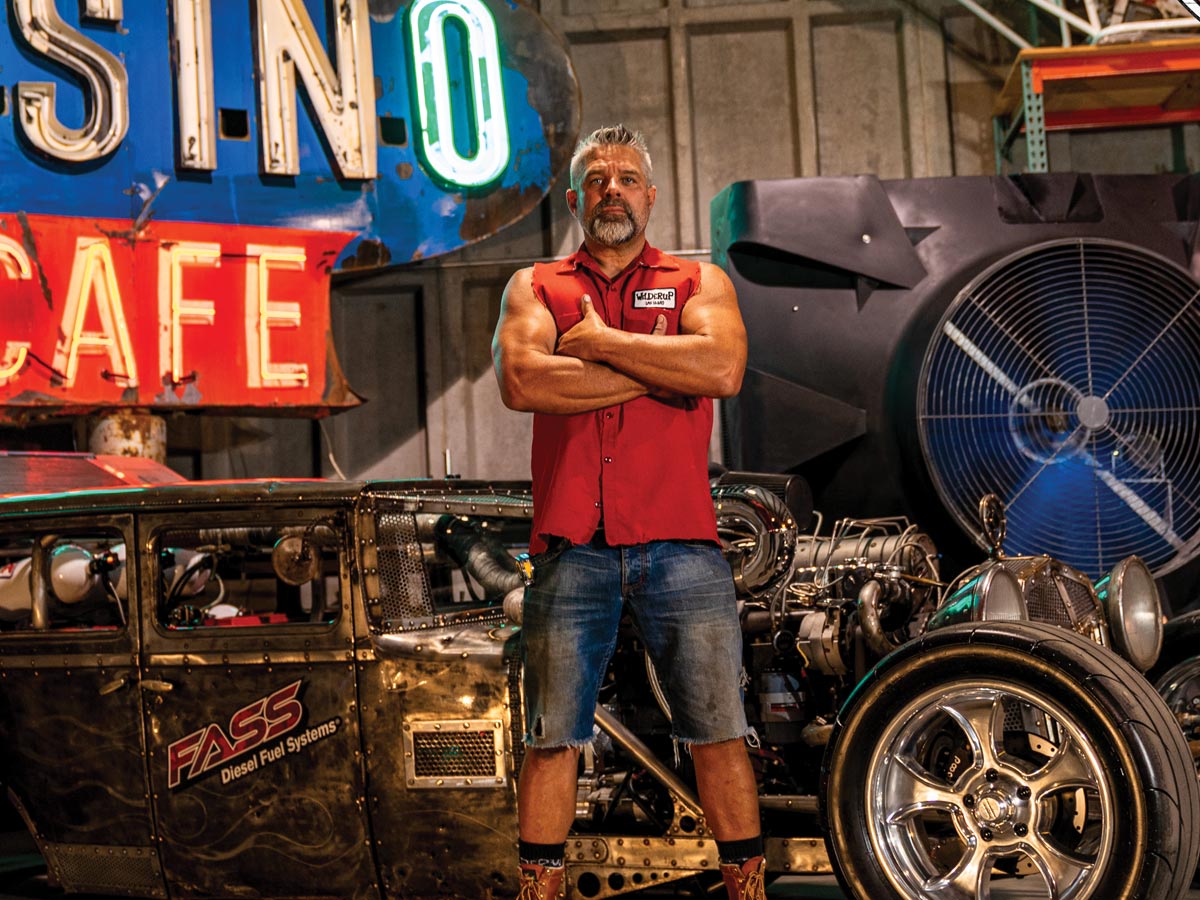 Photo of Steve Darnell originally from Billings, Mont., standing in front of his Rat Rod.