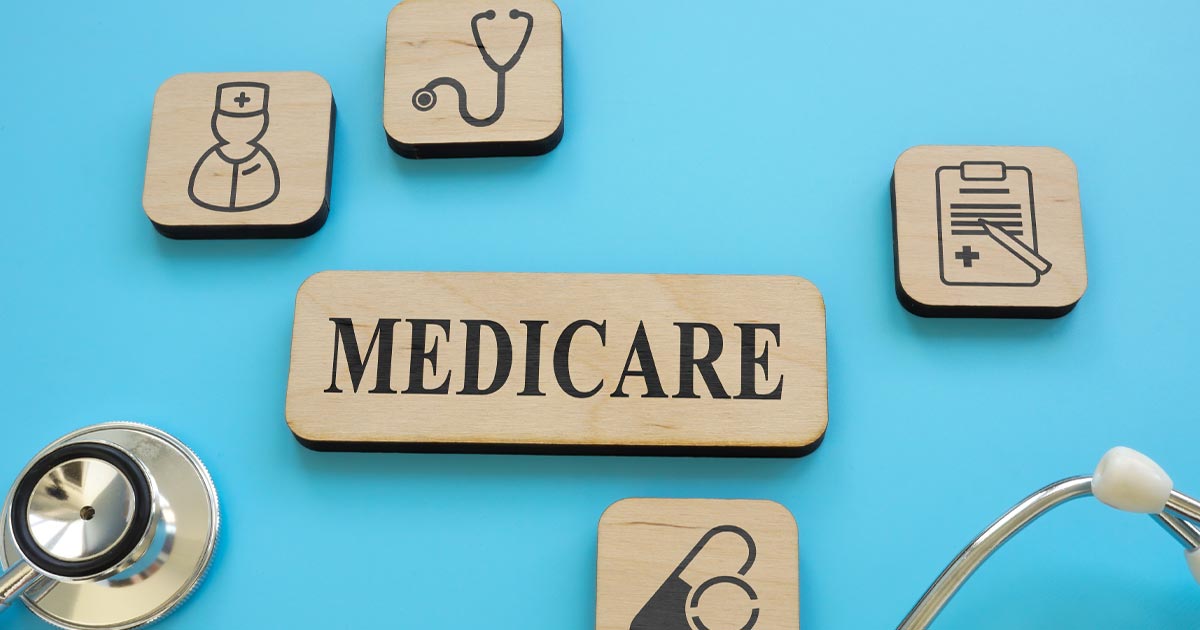 tiles with "Medicare" text on one. Others have medical icons. Stethoscope lies with tiles on a blue background