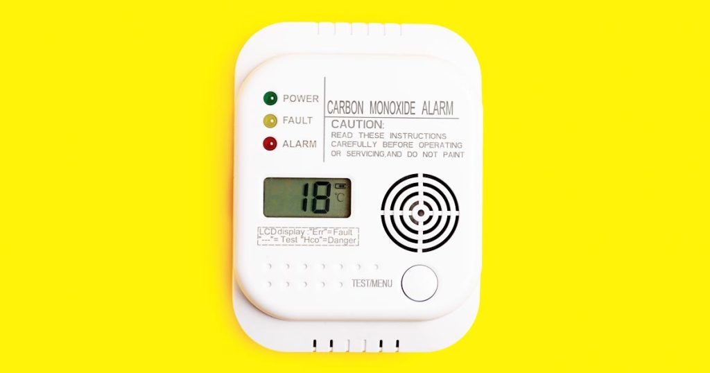 alarm for detecting carbon monoxide poisoning on a yellow background