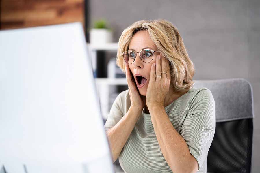 Distressed mature woman on computer.