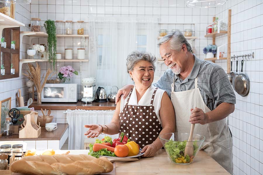 Senior couple working in kitchen