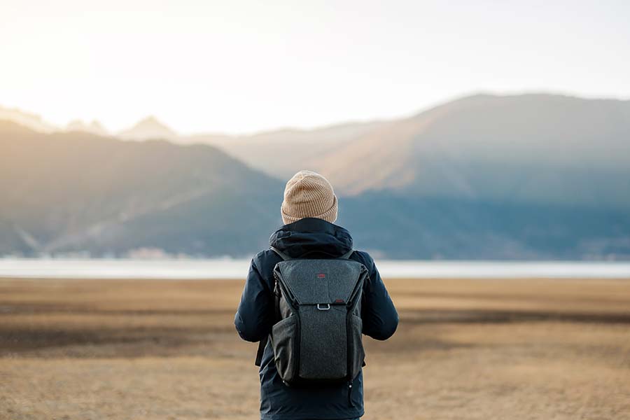 Man with backpack looking at mountains.
