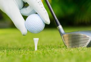 hand with golf ball and driver